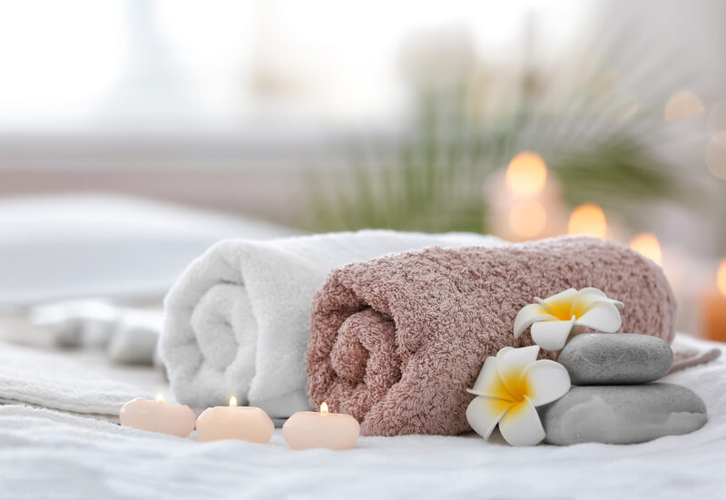 Relaxing wellness environment with towels, candles and natural elements